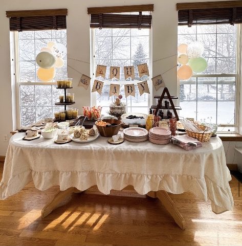 Home 9 A baby shower table set with a hand-lettered OH BABY banner, tiered treats and soft winter light through the windows