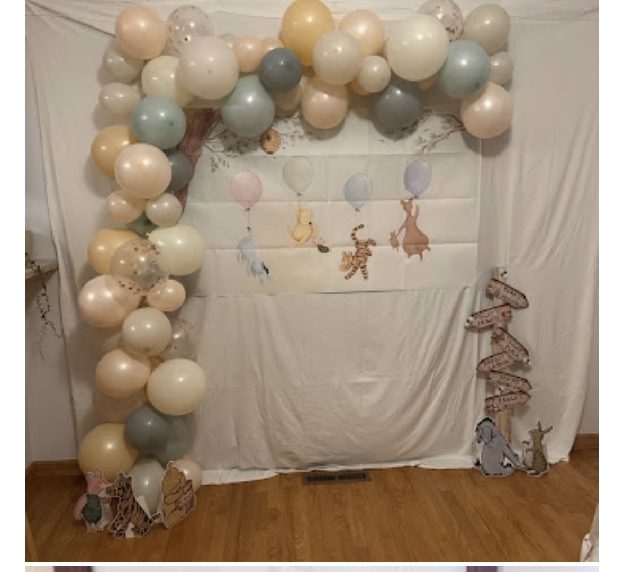 Home 8 A pastel balloon arch with woodland animal cut-outs above a draped baby shower backdrop