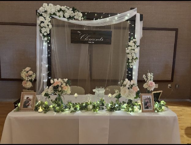 Home 14 A sweetheart table framed by a draped floral arch and lit with candlelight