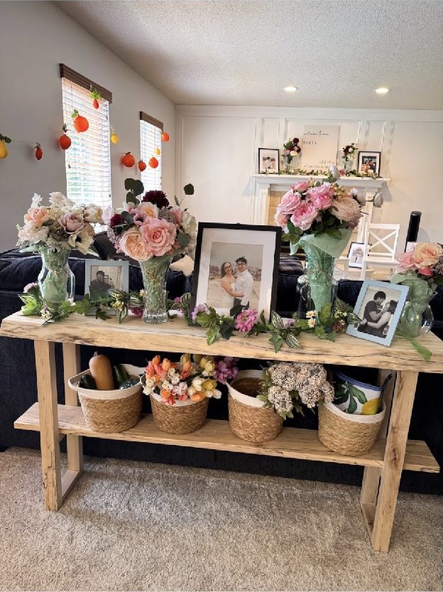 Home 2 A welcome table of framed family photographs, florals and woven baskets